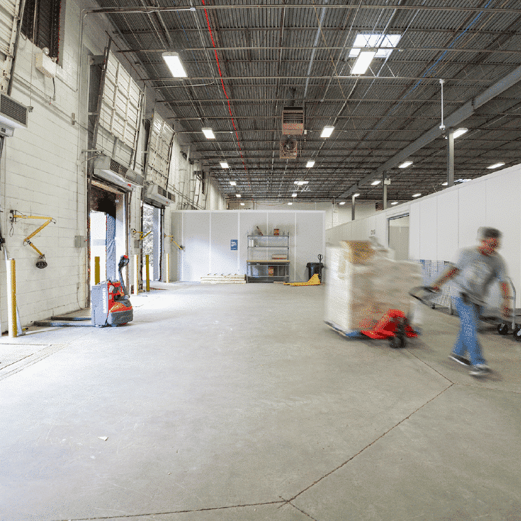 Warehouse space for rent with loading dock at Shift with pallet jacks, shipping desk, and truck-level loading docks.